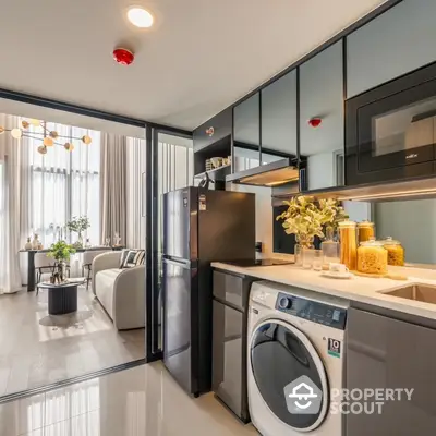 Chic modern apartment with an open layout kitchen featuring stainless steel appliances, sleek cabinetry, and a cozy living area with abundant natural light.