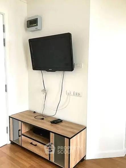 Modern living room with wall-mounted TV and stylish wooden cabinet