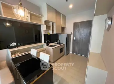 Modern kitchen with sleek cabinetry and dining area in a stylish apartment.