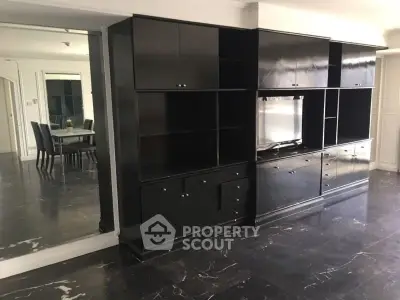 Spacious living room with sleek black cabinetry and elegant dining area, perfect for modern living.