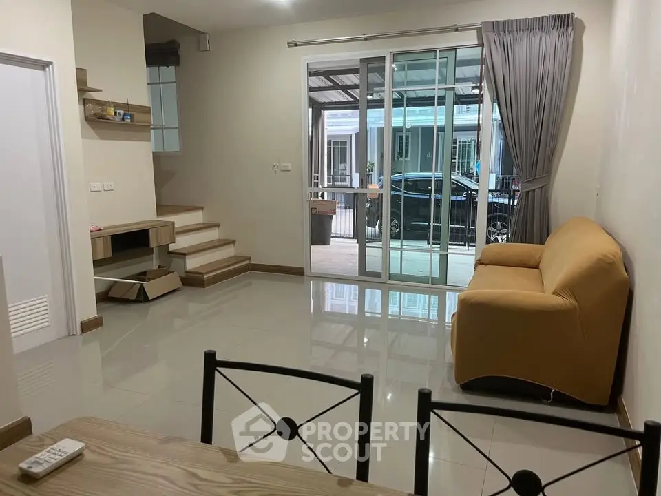 Spacious living room with modern furniture and large sliding glass doors leading to a patio.