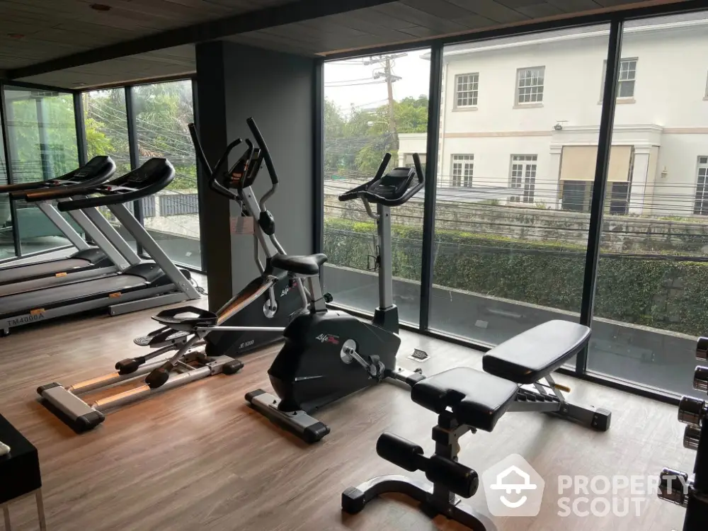 Modern gym with state-of-the-art equipment and large windows offering a scenic view.