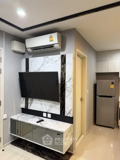 Modern living room with sleek TV setup and air conditioning in stylish apartment.