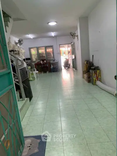 Spacious interior with green tiled flooring and open layout, ideal for versatile living space.