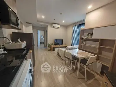 Modern open-plan living room with dining area and kitchen, featuring sleek design and cozy ambiance.