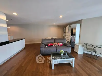 Spacious living room with modern furniture and hardwood floors in a stylish apartment.