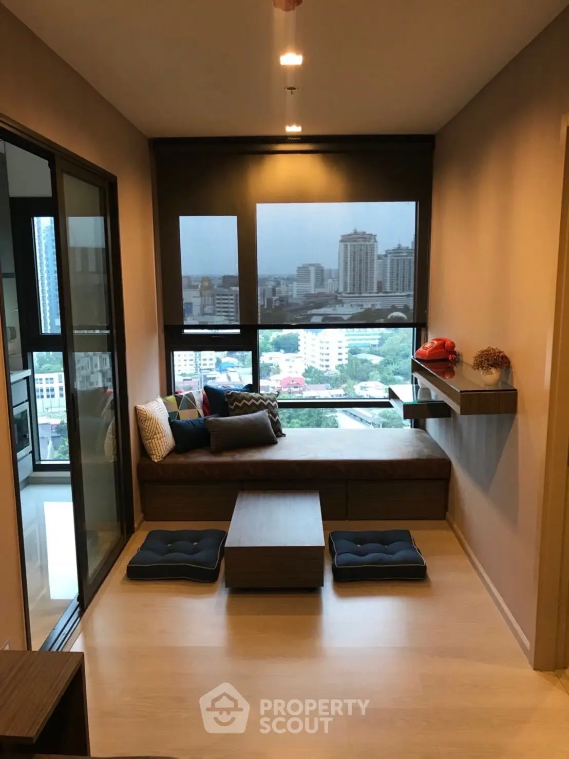 Modern living room with city view, cozy seating, and stylish decor in urban apartment.