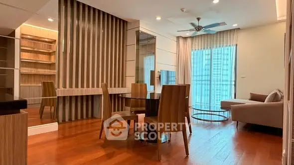 Modern living room with wooden flooring, stylish furniture, and large windows for natural light.