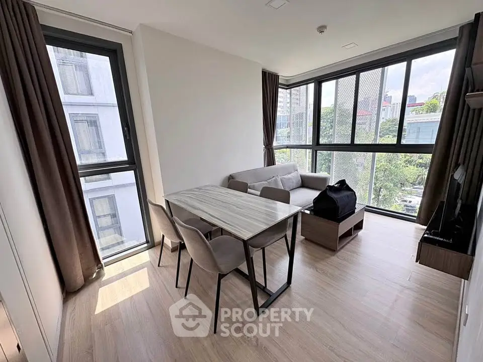 Modern living room with large windows and stylish furniture in a bright apartment.