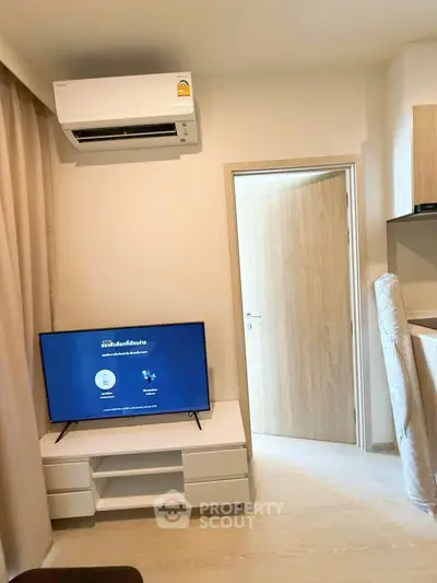 Modern living room with air conditioning and flat-screen TV in cozy apartment.