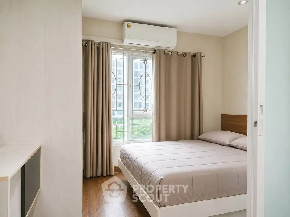 Modern bedroom with large window and air conditioning in a stylish apartment.
