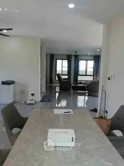Spacious modern living room with elegant dining area and large windows for natural light.