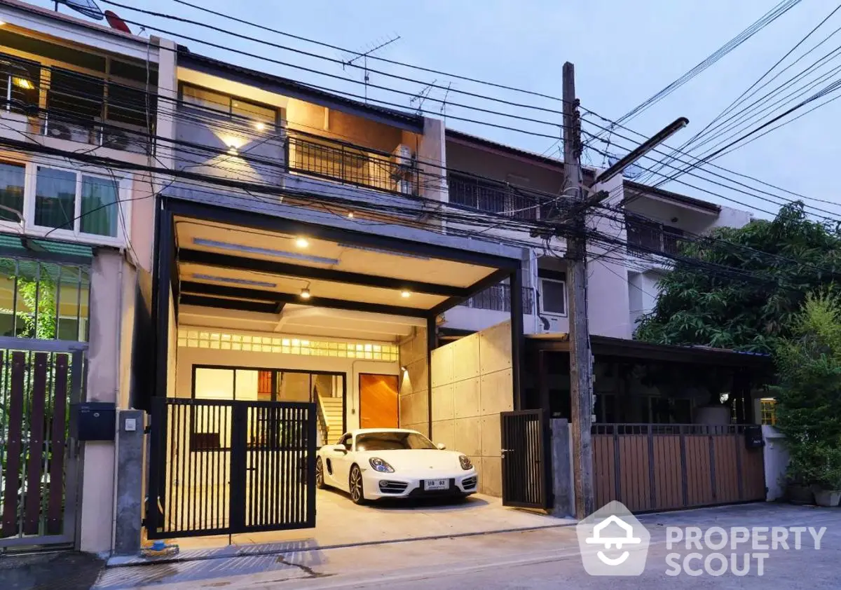 Modern townhouse with sleek garage and luxury car, featuring contemporary design and urban street view.