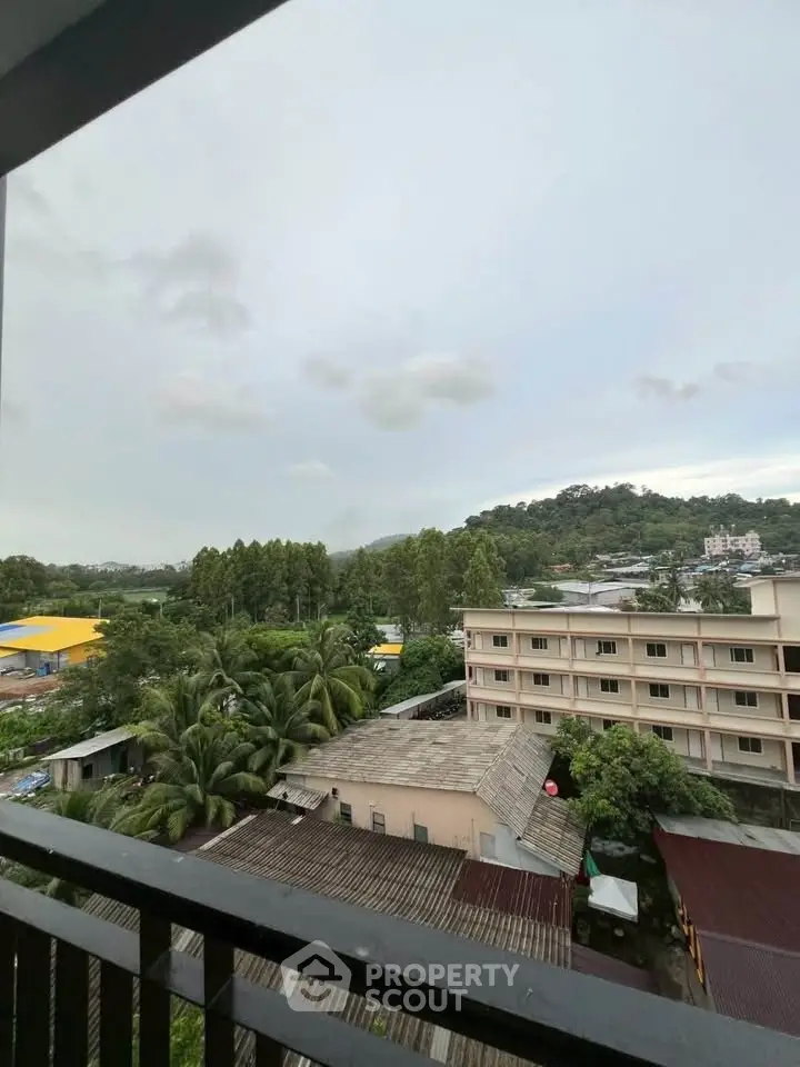 Scenic view from balcony overlooking lush greenery and distant hills, perfect for nature lovers.