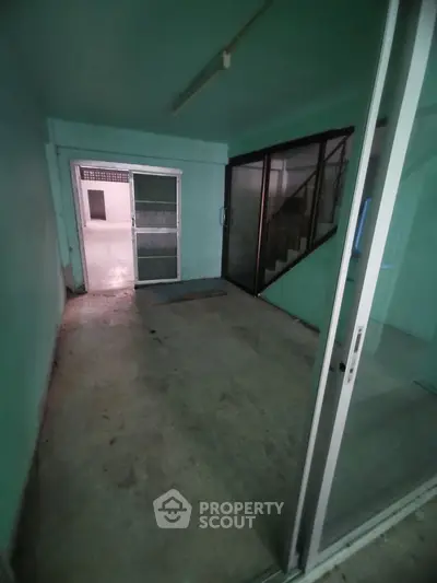 Spacious entryway with sliding glass doors and stair access, ideal for versatile use.