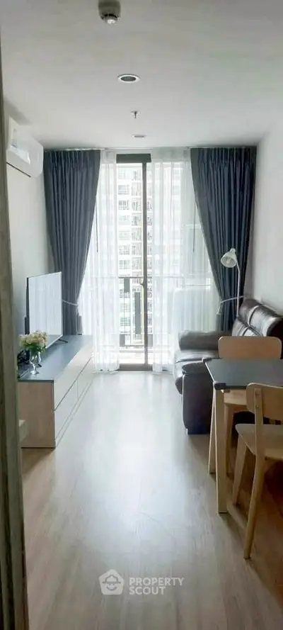 Cozy living room with modern furniture and large window in urban apartment