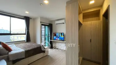 Modern bedroom with balcony and TV, featuring sleek design and ample natural light.