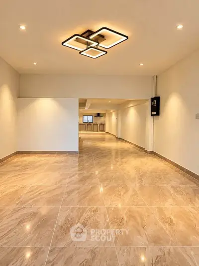 Spacious modern living room with elegant lighting and marble flooring.