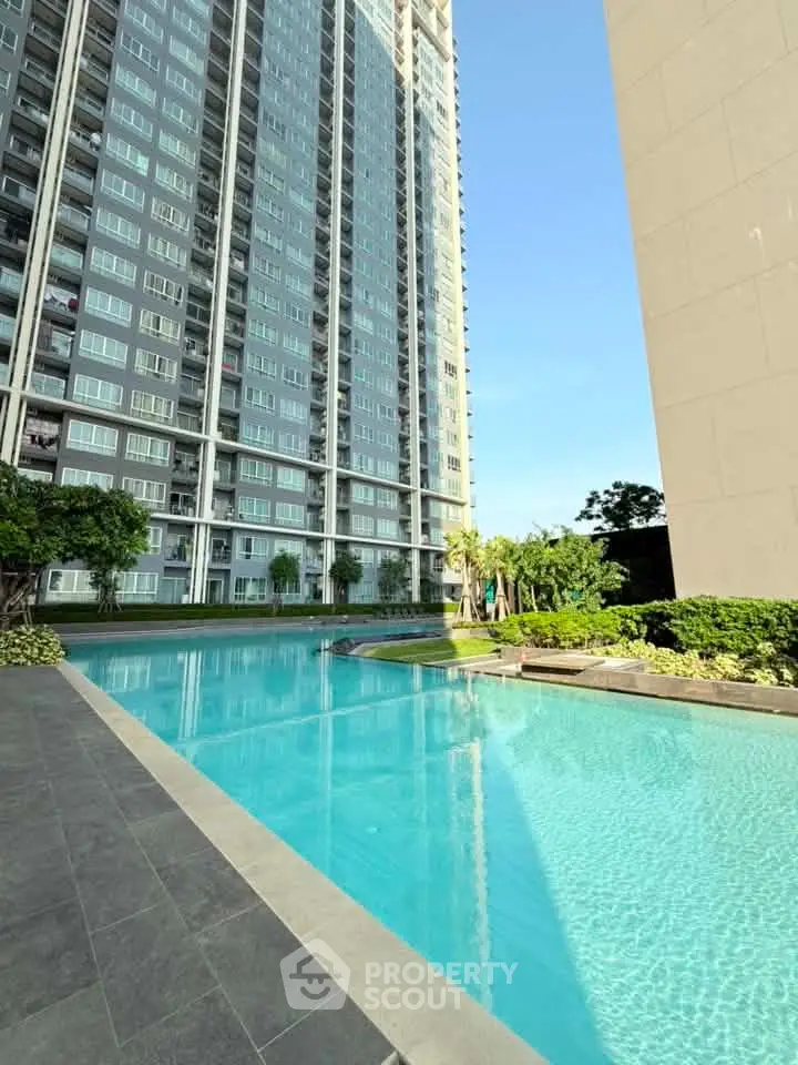 Luxurious high-rise building with stunning pool and lush greenery, perfect for modern urban living.