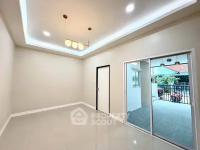 Spacious modern living room with elegant lighting and sliding glass doors leading to a balcony.