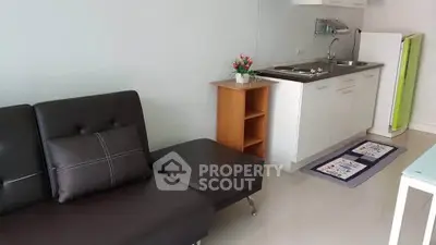 Cozy studio apartment with modern kitchenette and stylish sofa, perfect for urban living.