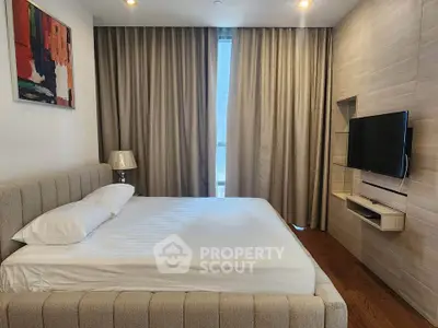 Luxurious bedroom with modern decor and wall-mounted TV in a high-end apartment.