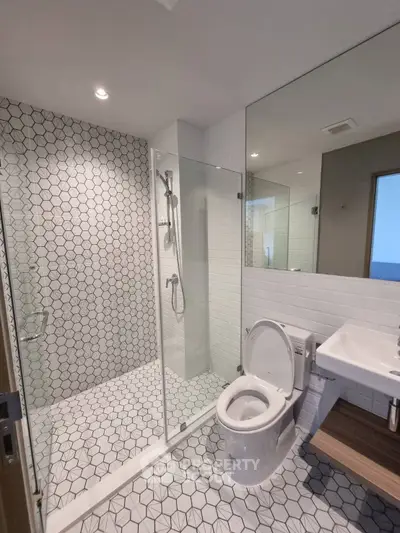 Modern bathroom with geometric tiles and glass shower enclosure