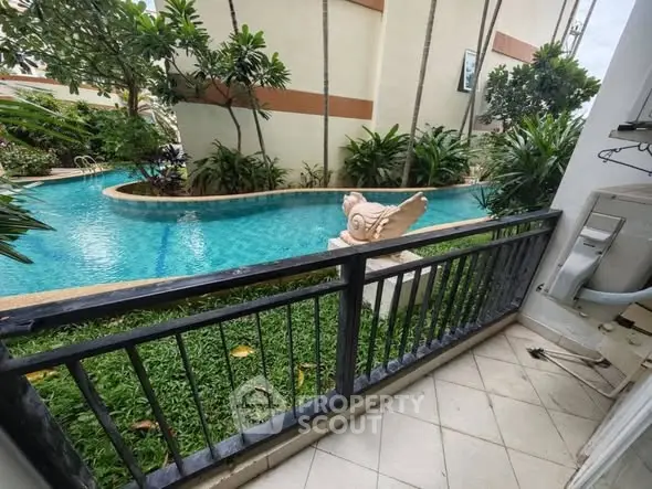 Charming poolside view from a cozy balcony in a tropical setting, perfect for relaxation.