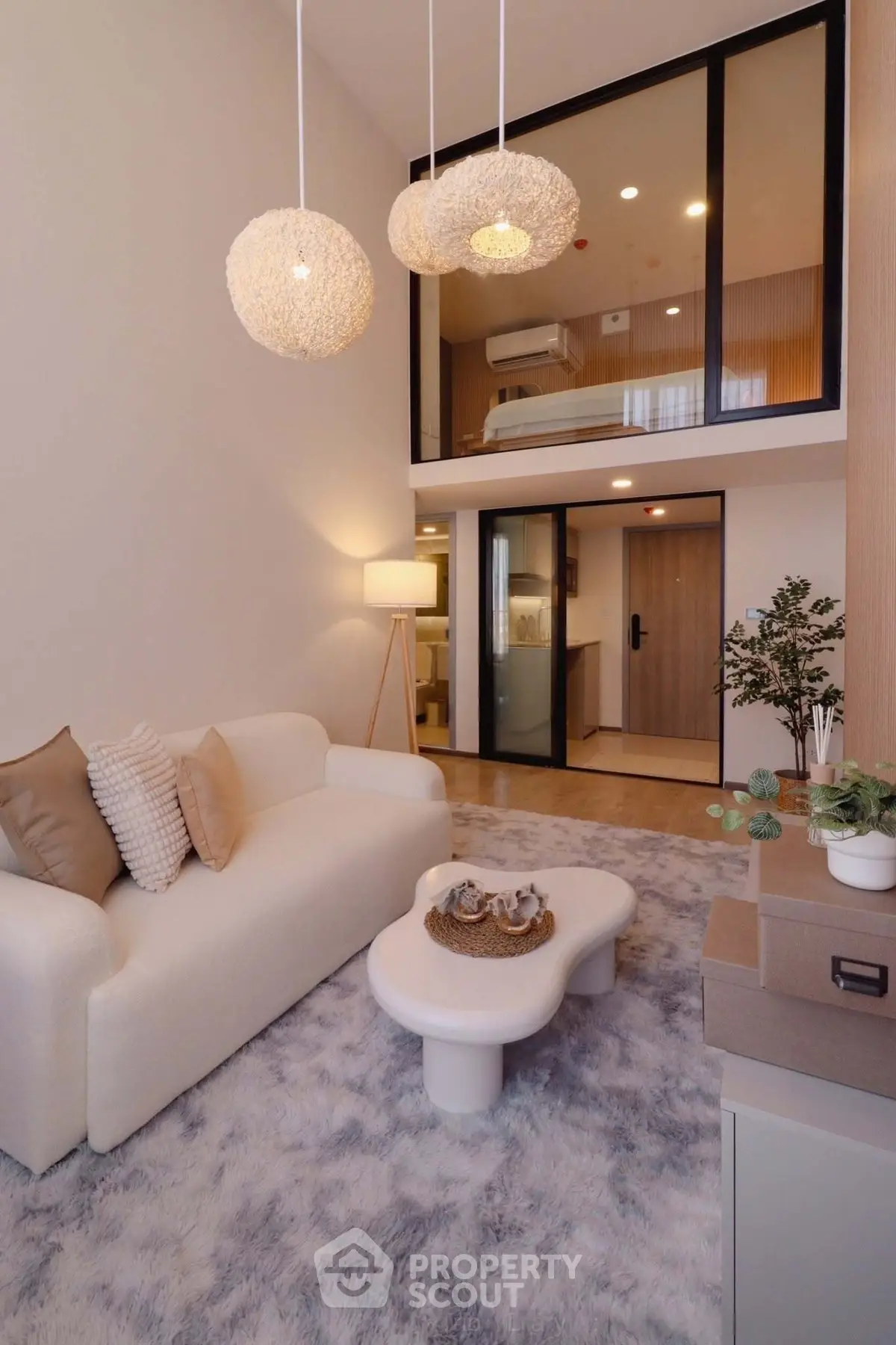 Modern living room with high ceiling and mezzanine, featuring cozy sofa and stylish decor.