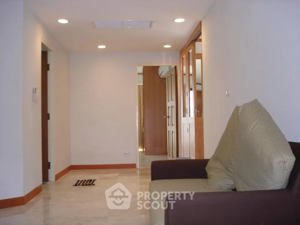 Spacious living room with modern lighting and comfortable seating in a contemporary apartment.