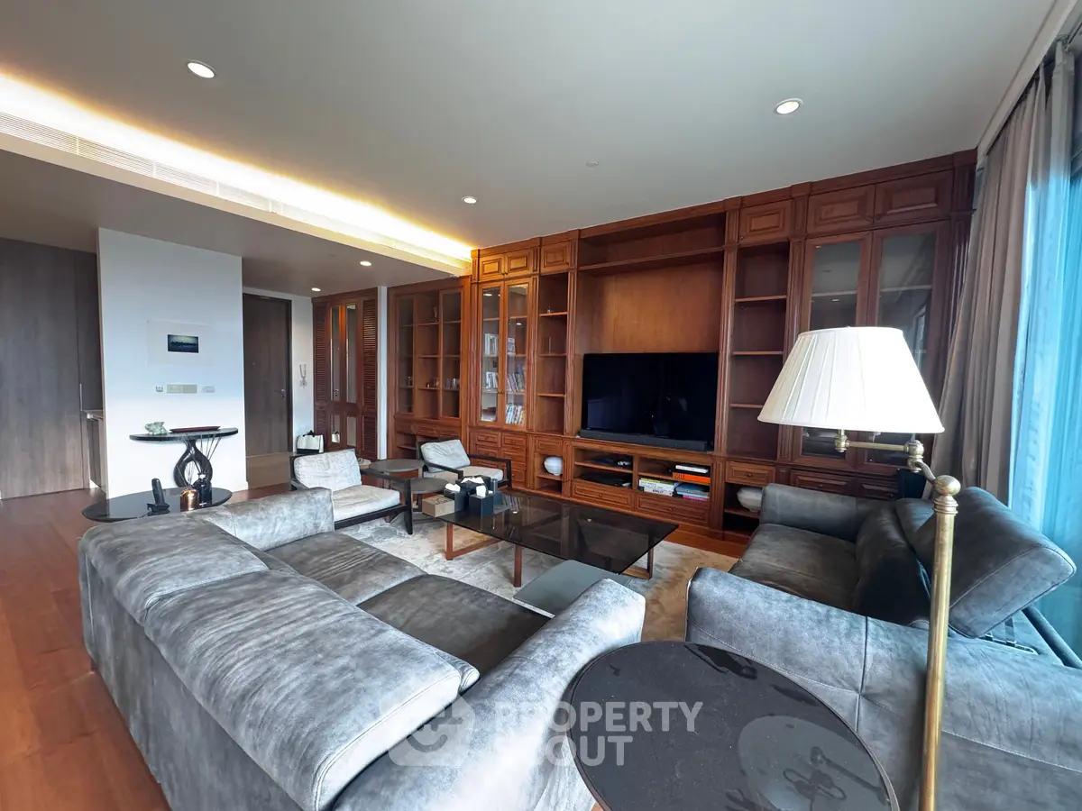 Luxurious living room with elegant wooden cabinetry and plush gray sofas, perfect for relaxation and entertainment.
