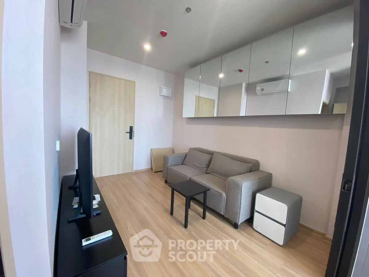 Modern living room with sleek furniture and mirrored cabinets