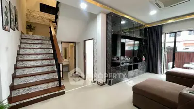 Spacious modern living room with elegant staircase and large TV unit