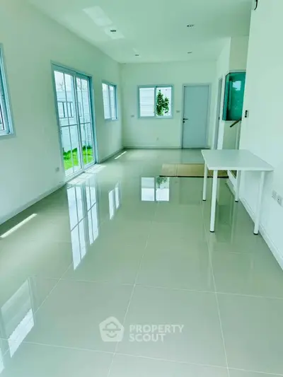 Spacious and bright living room with large windows and glossy tiled floors