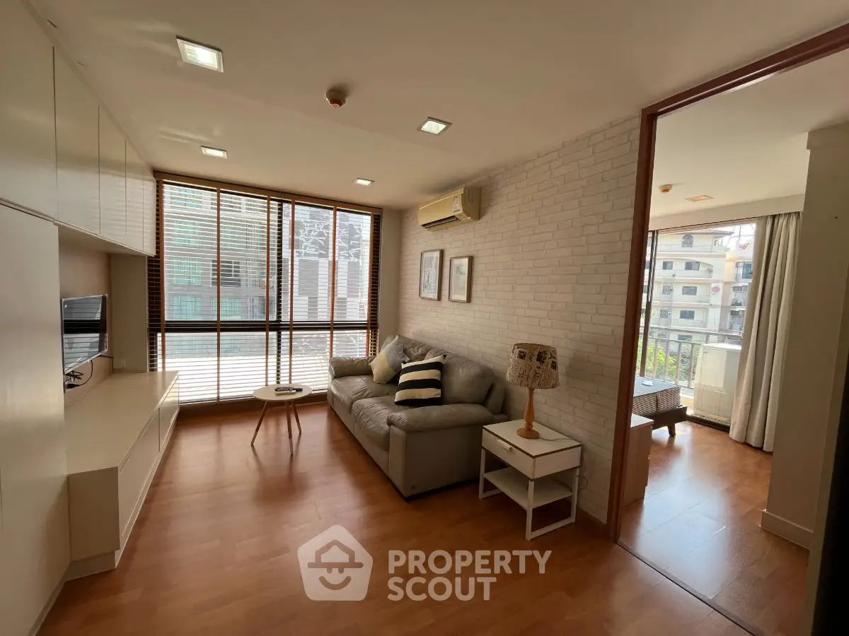 Spacious living room with modern decor and large windows in a stylish apartment.