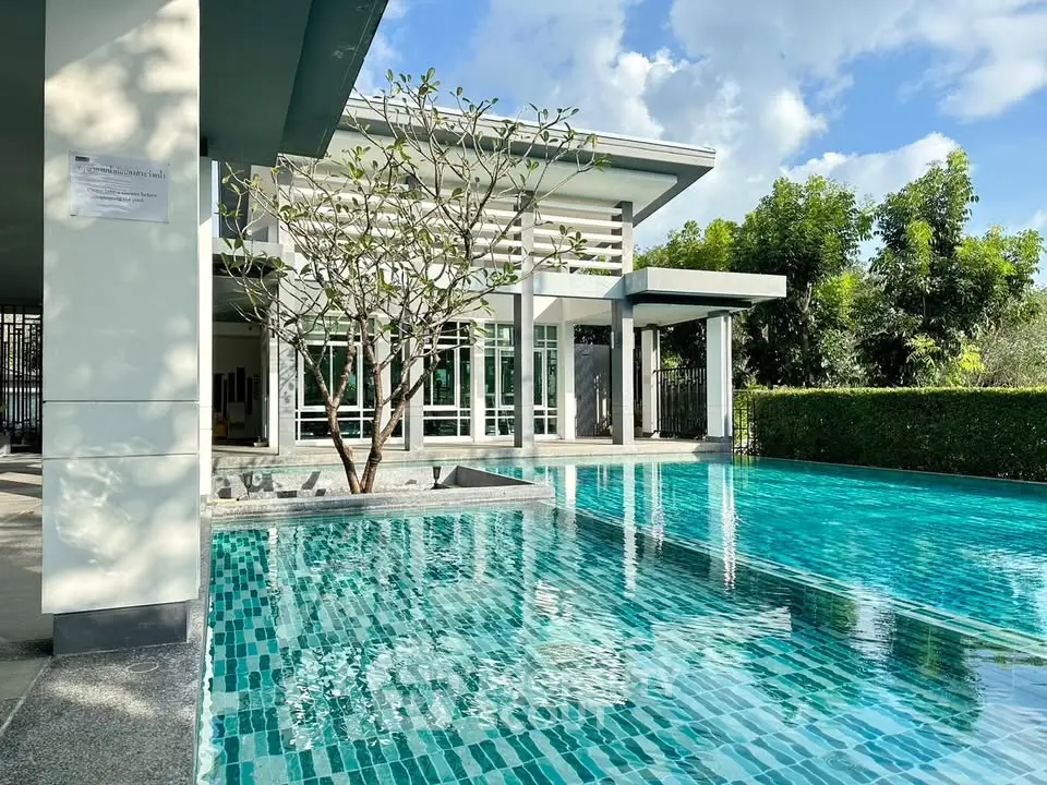 Luxurious modern home with stunning pool and lush greenery, perfect for relaxation and entertaining.