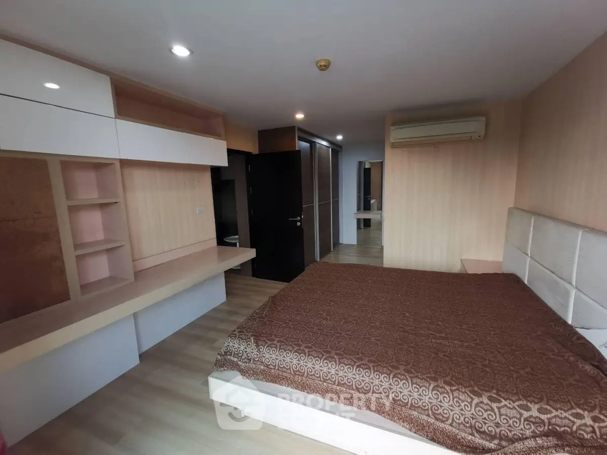 Spacious bedroom with modern design and ample storage in a luxury apartment.