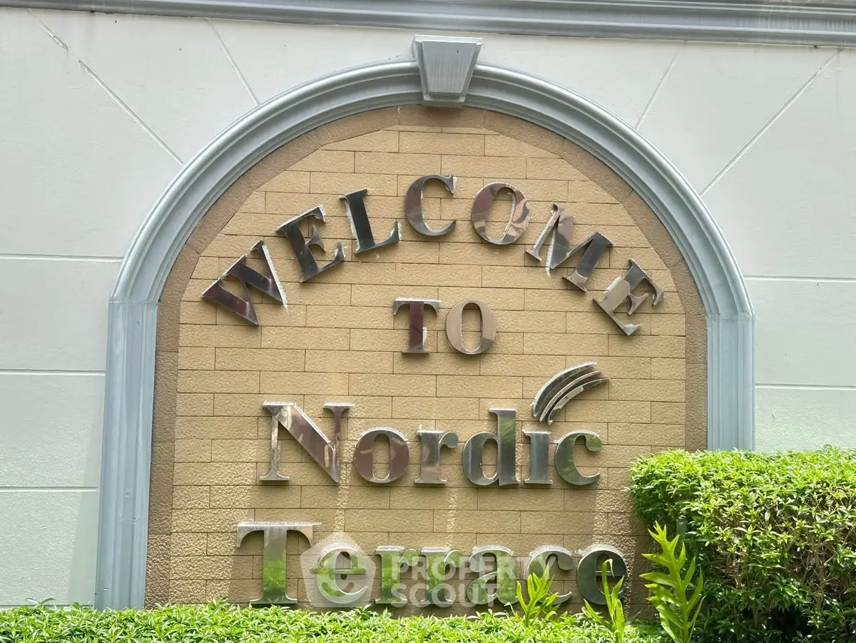 Welcome sign at Nordic Terrace entrance with lush greenery.