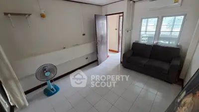 Cozy living room with sofa and fan, bright window view