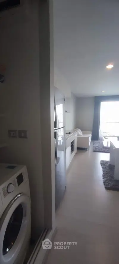 Modern apartment with open layout, featuring kitchen and living area with natural light.