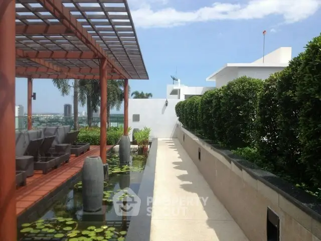 Luxurious rooftop garden with modern seating and water feature offering stunning city views.