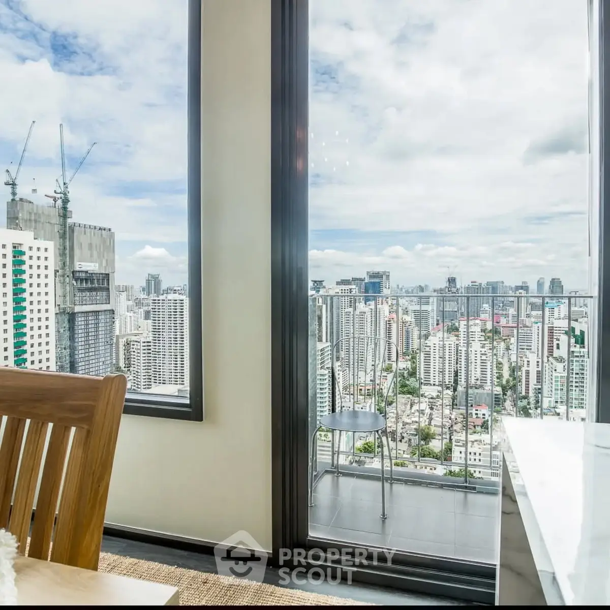 Stunning city view from high-rise apartment balcony with modern interior.