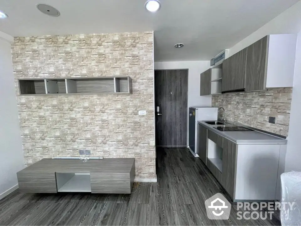 Modern kitchen with sleek cabinetry and stone accent wall in stylish apartment