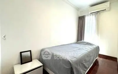 Cozy bedroom with natural light and air conditioning in modern apartment.