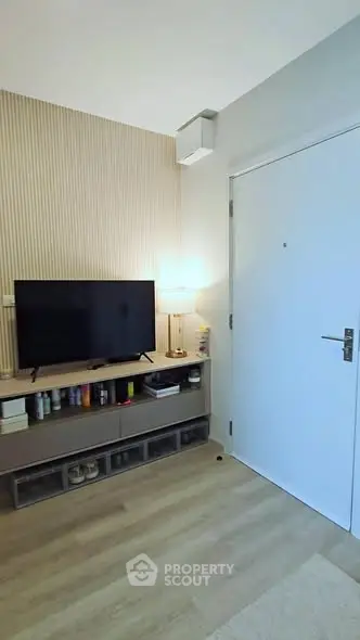 Modern living room with TV and stylish decor, featuring a sleek wooden floor and contemporary design.
