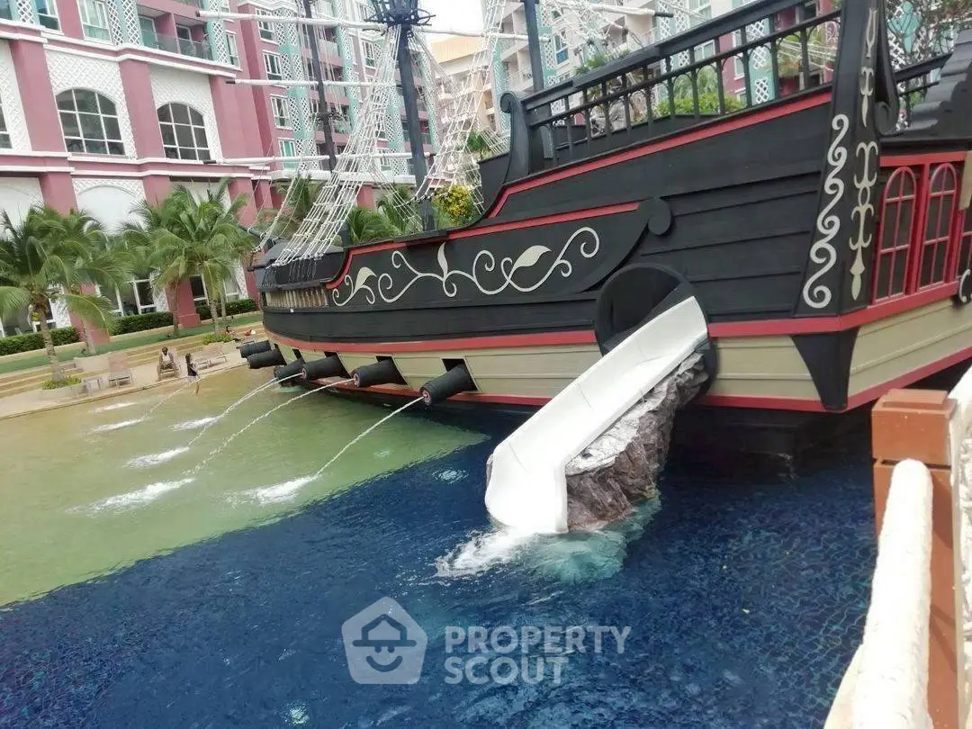 Luxurious resort pool with pirate ship slide and tropical landscaping.