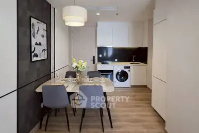 Modern dining area with stylish kitchen and washing machine in open layout apartment.