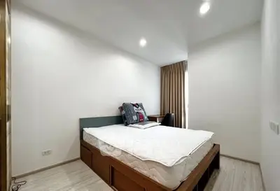 Modern bedroom with cozy bed and natural light, perfect for relaxation.