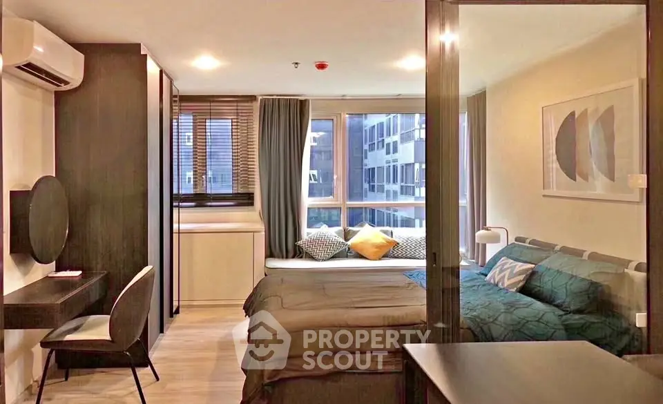 Modern bedroom with large windows and stylish decor in urban apartment.