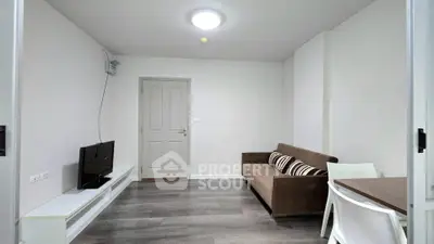Modern living room with sleek flooring and cozy sofa in a minimalist apartment.